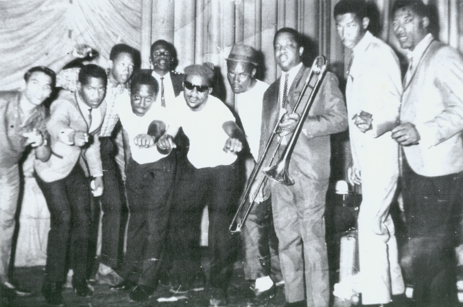 Carlos (with trombone) backstage with some of the contestants of the Jamaican Hit Parade, which Carlos helped to create. The show was produced live from the stage of the Regal Theatre in Cross Roads, Kingston Jamaica from 1959. (Second from left) Alphonso Castro and Lascelles Perkins (extreme right)