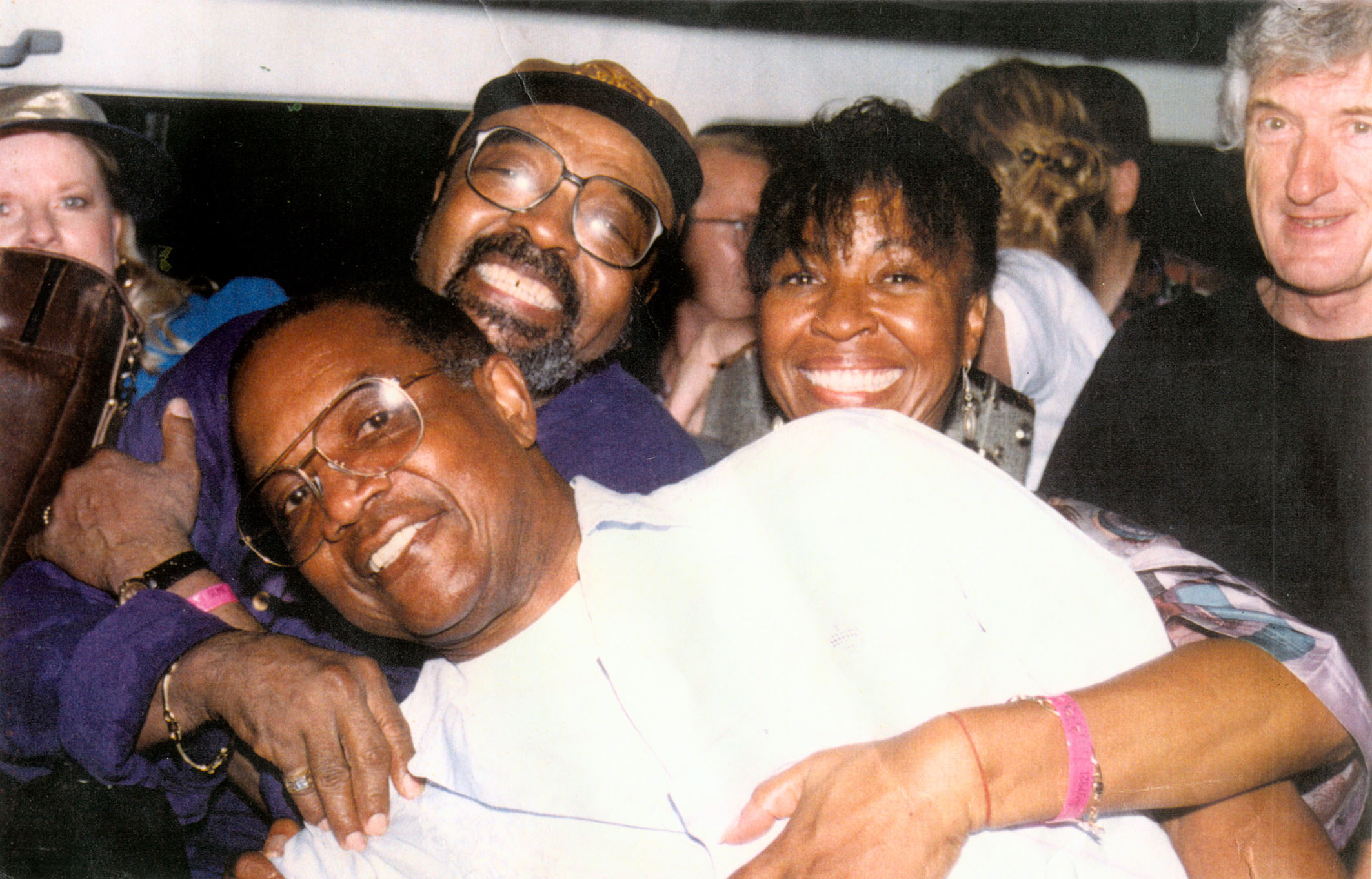 Three smiling faces in forefront. (Left to right) Carlos Malcolm, James Moody- famous international Jazz tenor saxophone/flutist and Myrna Hague-Bradshaw, singer and wife of Sonny Bradshaw, founder of the Ocho Rios Jazz Festival, Both Moody and Malcolm were inducted into Hall of Fame of Ocho Rios Jazz Festival.